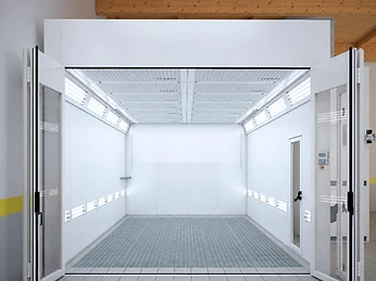 Interior of a Nova Verta downdraft spray booth showing the ceiling filtration grid, the side wall lighting strips and the grated floor