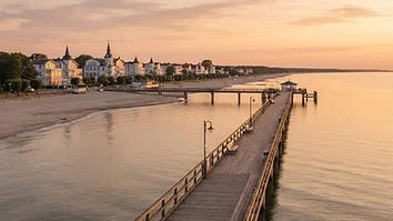 Hölzerne Seebrücke an der Ostseeküste im warmen Abendlicht