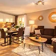 Wohnbereich mit Sofa, Couchtischen und Küchenzeile