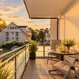 Für zwei Personen gedeckter Tisch auf dem Balkon mit Weingläsern und Blumen