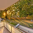 Blick vom Balkon über den Garten und die Bäume im Abendlicht