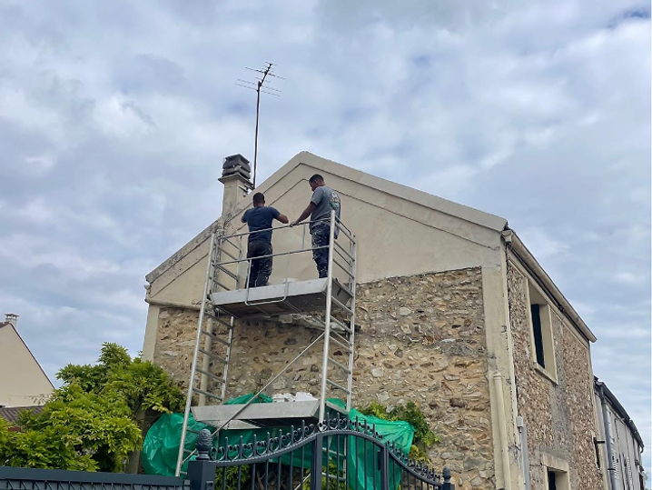 Ravalement de façade en pierre sur échafaudage, pignon de maison en cours de rénovation