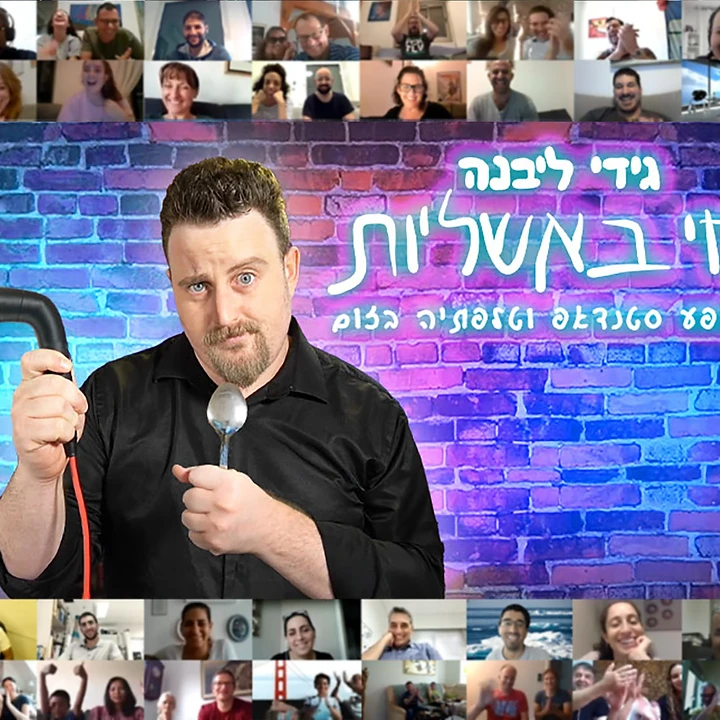 גידי ליבנה מחזיק מיקרופון וכף על רקע קיר לבנים עם צילומי מסך משיחת זום.