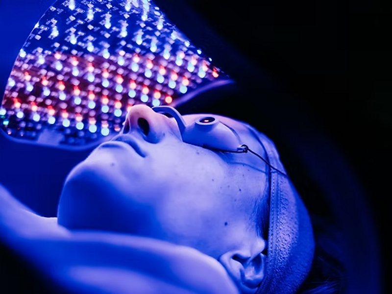 Client receiving LED light therapy with protective eyewear