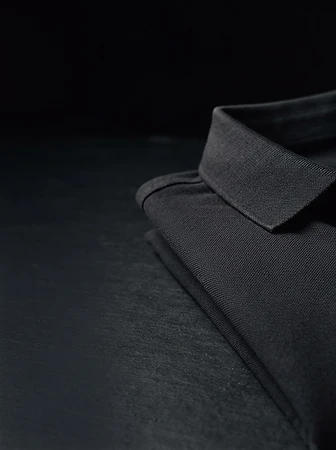 A tailored dark piqué polo, the ready-to-wear expression of the House
