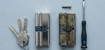 Nieuwe cilinder met sleutels naast de versleten cilinder die vervangen wordt