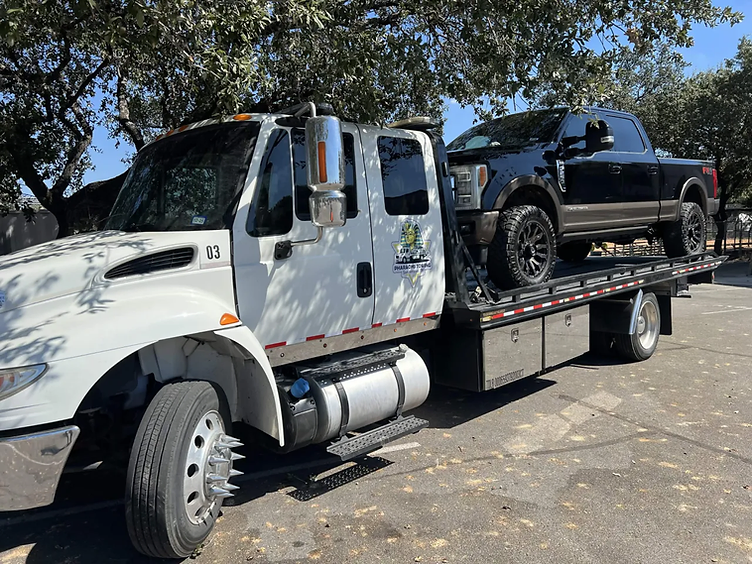 Ford F-250 loaded on a Pharaohs flatbed tow truck under shade