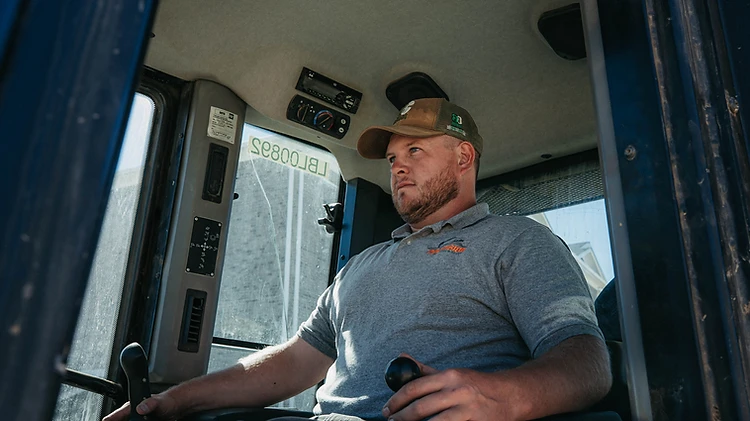 Precision equipment operator at the controls of a Caterpillar 963K track loader
