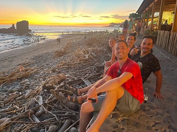 Sunset on the beach in El Tunco, friends sitting on the seawall