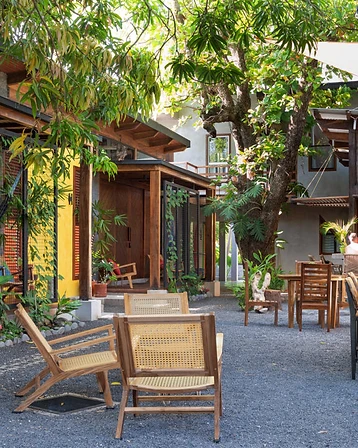 Tropical courtyard with wooden lounge chairs and string lights