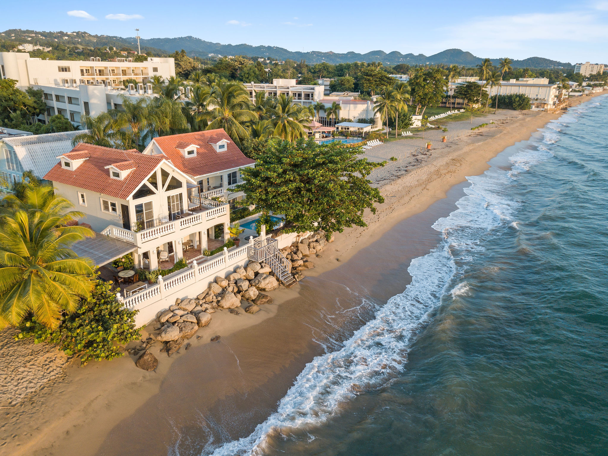 Aerial view of a beachfront surf retreat on El Salvador's Pacific coast at golden hour