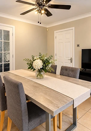 Kitchen dining space with a wooden table and floral centrepiece