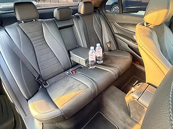 Banquette arrière en cuir noir d'une Mercedes Classe E, toit panoramique ouvert