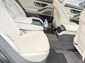 Sièges arrière en cuir crème d'une Mercedes Classe S, place Vendôme en arrière-plan