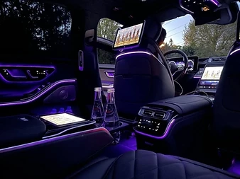 Habitacle arrière d'une Mercedes Classe S avec écrans, tablette et éclairage d'ambiance