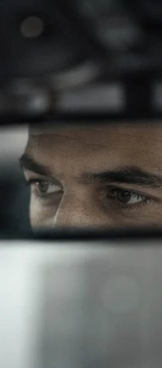 Mirada de un chófer concentrado en la carretera, vista en el retrovisor interior