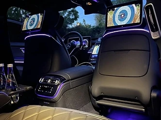 Sièges arrière matelassés d'une Mercedes Classe S, écrans de divertissement et éclairage d'ambiance