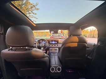 Intérieur d'une Mercedes Classe E vu depuis la banquette arrière, sous le toit panoramique