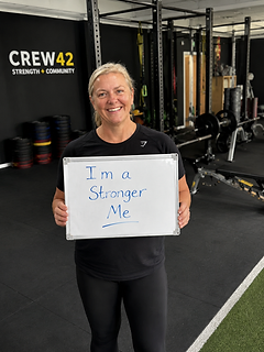 Crew42 member holding a stronger me testimonial sign