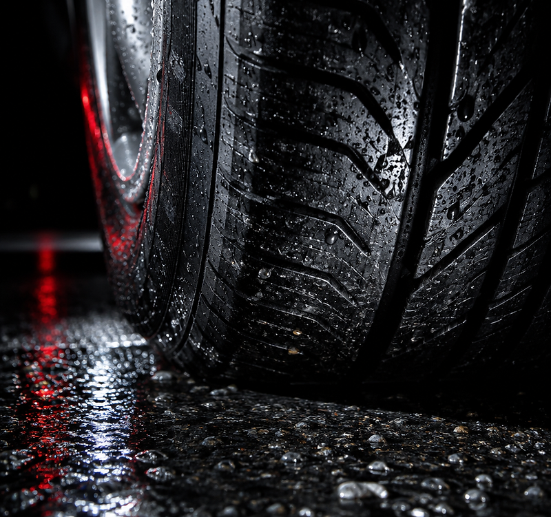 Forensic macro of a tyre contact patch on wet asphalt at night