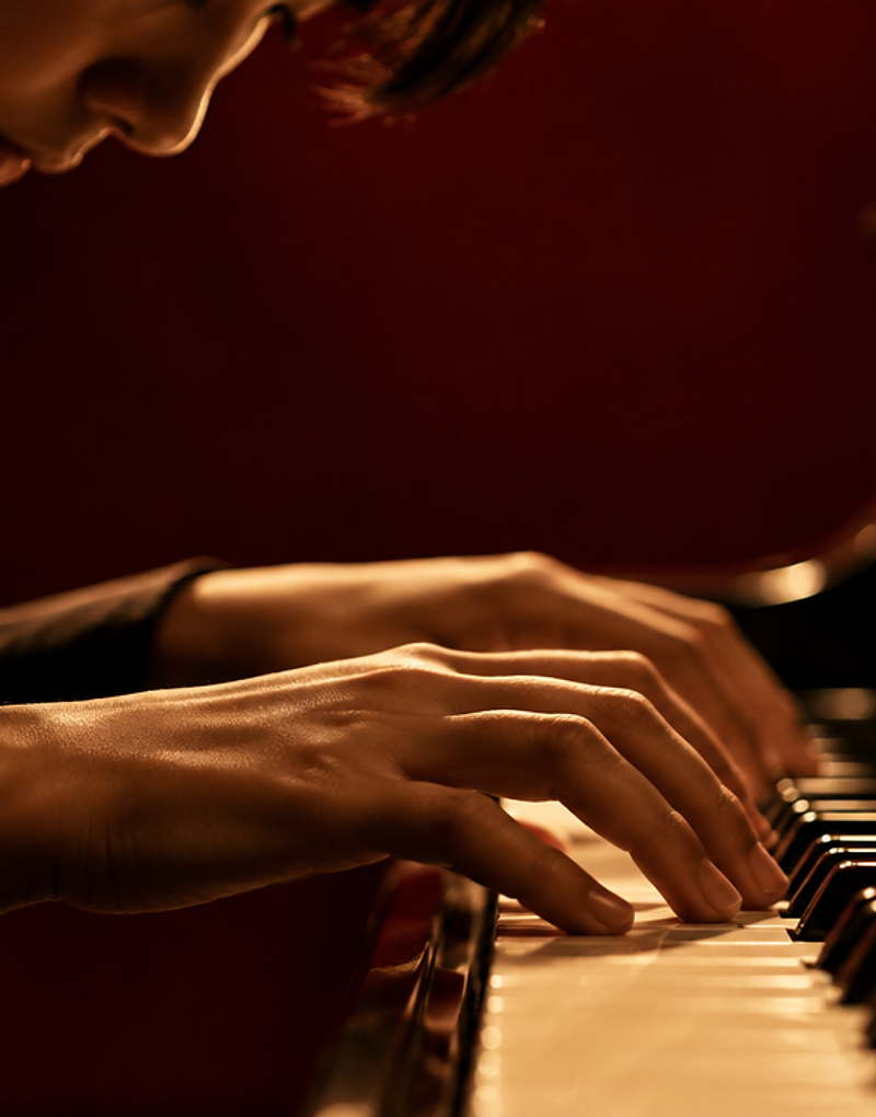 Estudiante tocando el piano con iluminación cinematográfica