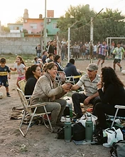 Grupo de familias alentando en la banda del partido