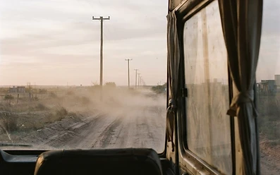 Camino de tierra al amanecer, visto desde la combi del equipo