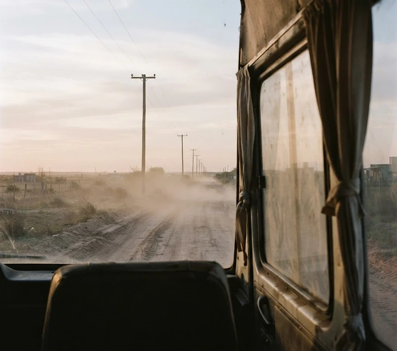 Camino de tierra al amanecer, visto desde la combi del equipo