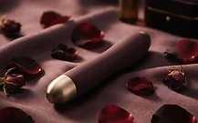 A premium intimate product on dark silk with rose petals
