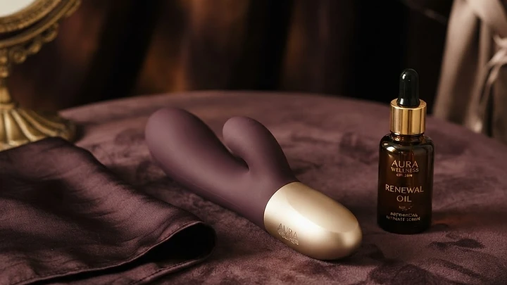 A luxury intimate toy beside folded silk on dark velvet