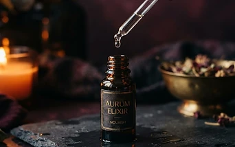 An apothecary dropper bottle releasing a drop in warm light
