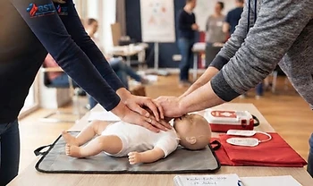 Hände üben die kindgerechte Reanimation an einer Baby-Übungspuppe