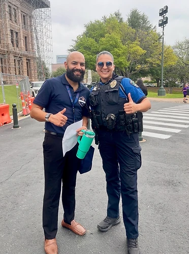 Cumbre Group founder with a local law enforcement partner outside a community building renovation