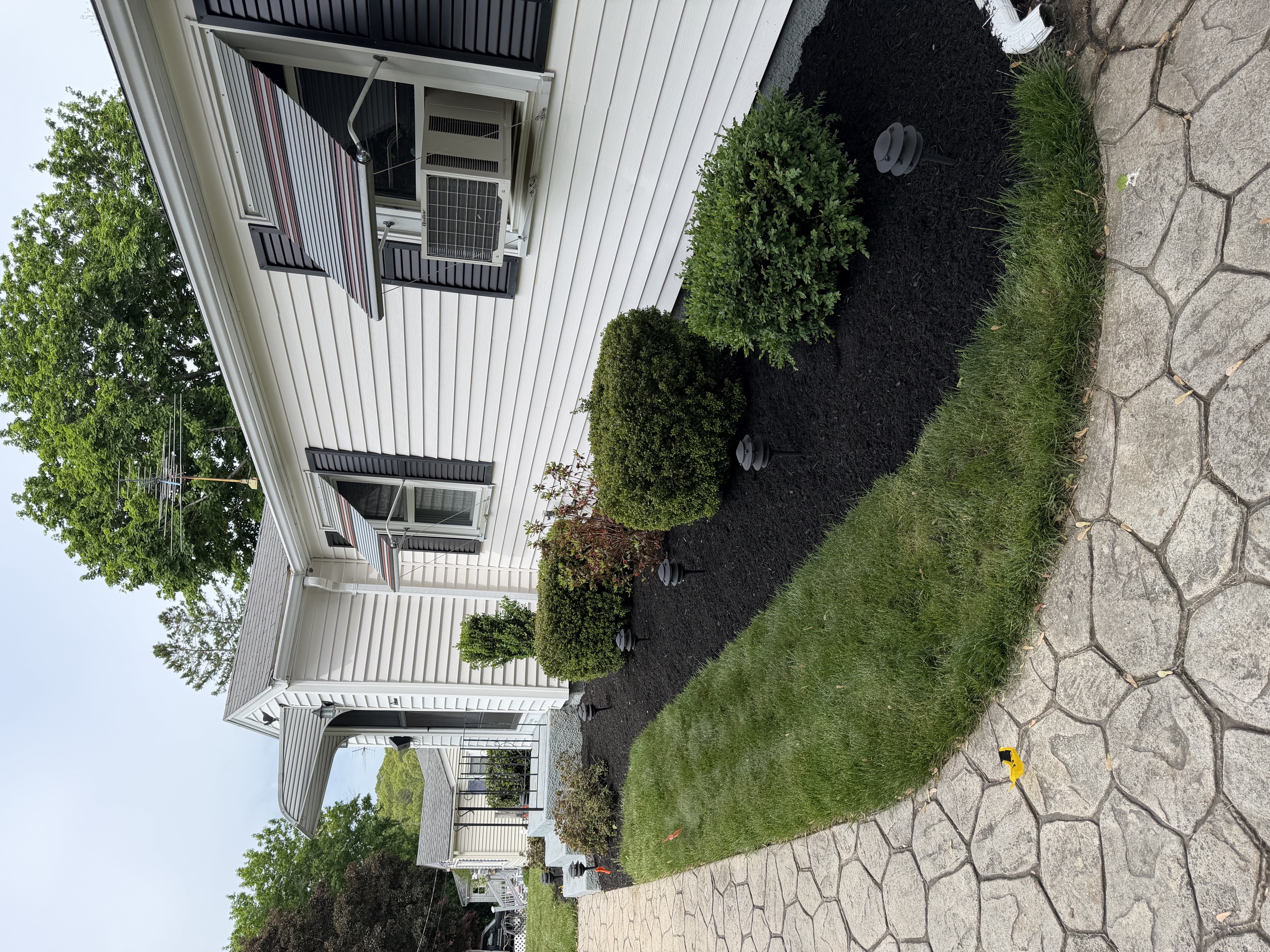 Fresh dark brown mulch installed in landscape beds around a home in North Smithfield, RI