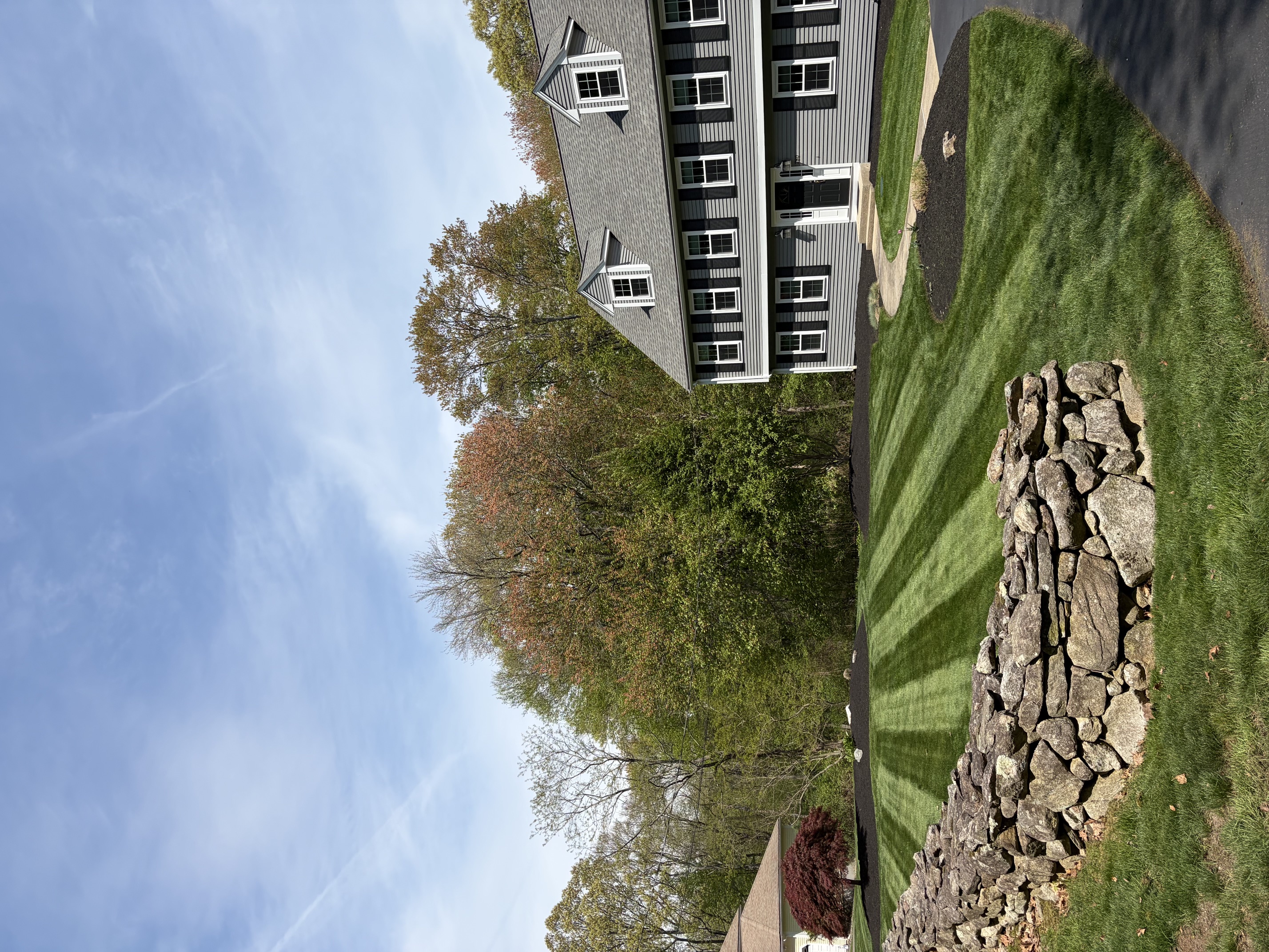 Natural stone wall bordering a neatly maintained lawn in North Smithfield, RI