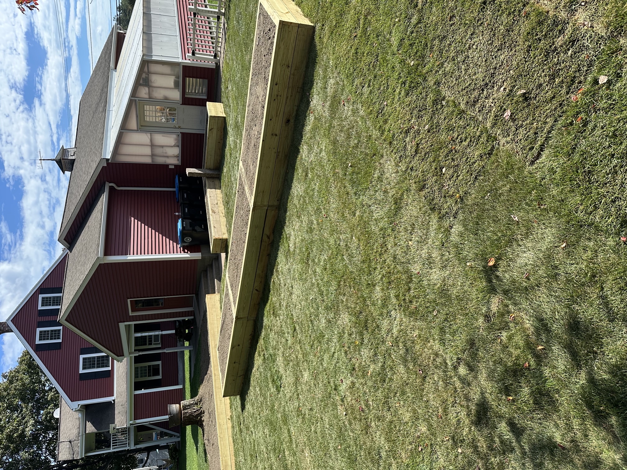 Fresh sod installation creating a new lush lawn in a landscaped backyard in North Smithfield, RI