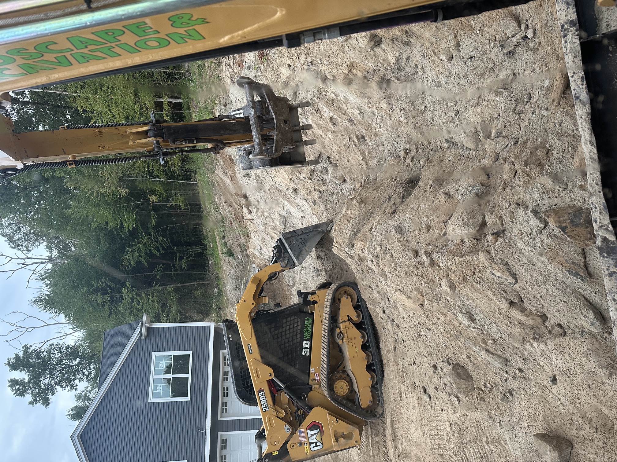 Excavator digging a utility trench on a residential job site in North Smithfield, RI