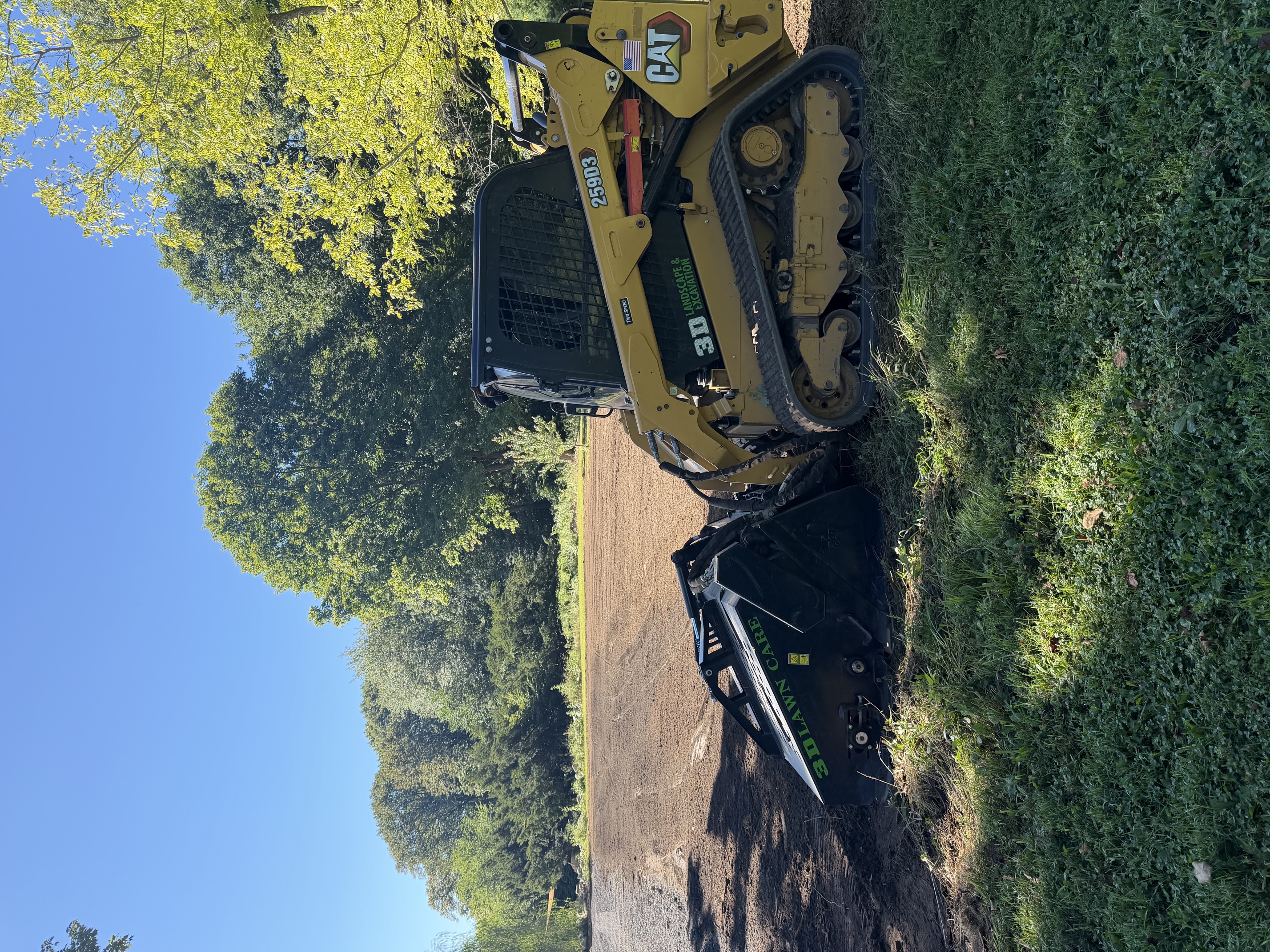Cleared and mulched open area prepared for new lawn installation on a residential property in Rhode Island