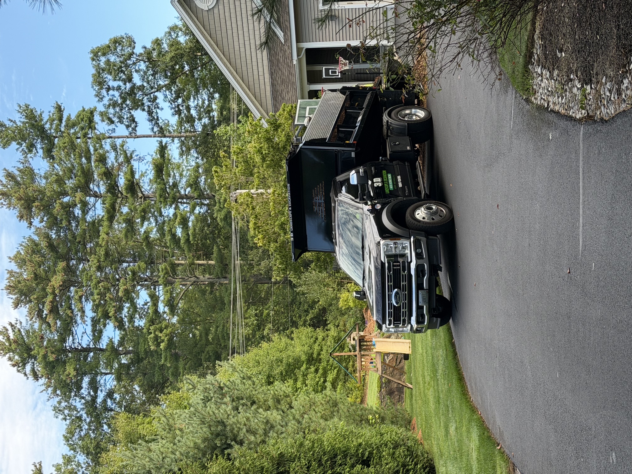 Truck and crew hauling away yard debris and branches after a property cleanup in North Smithfield, RI