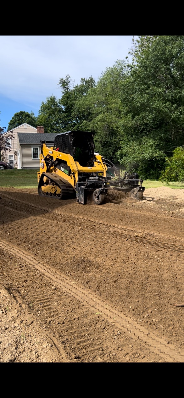 Excavator grading a residential building site to level ground in Rhode Island