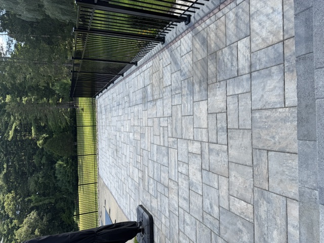 Large poolside paver patio with black aluminum fence in North Smithfield, RI