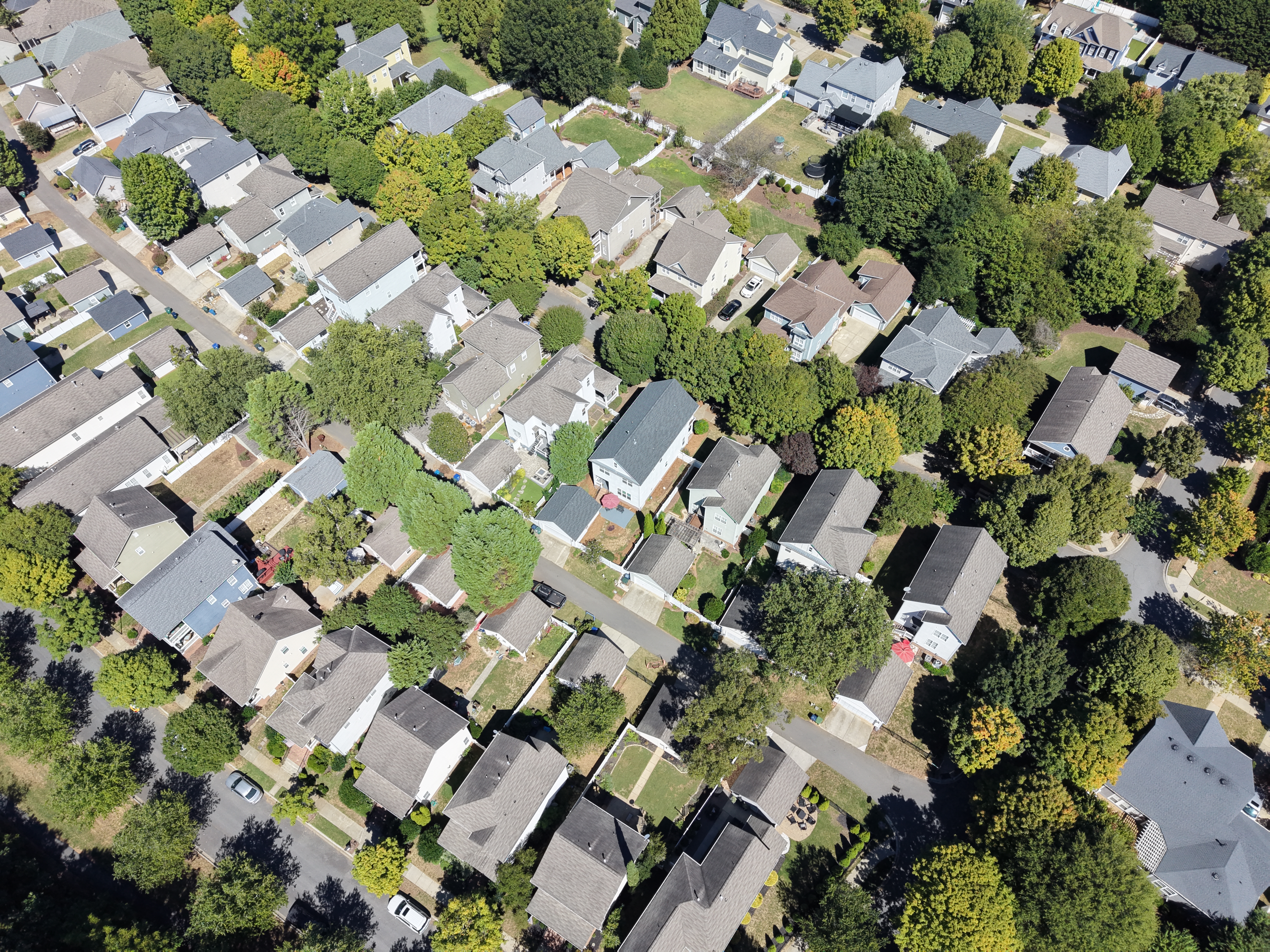 Oblique aerial view of a residential neighborhood with mature trees