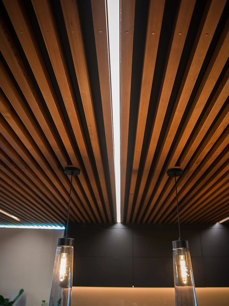 Integrated linear and pendant lighting in a timber feature ceiling