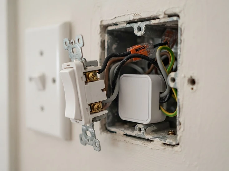 A compact smart module installed behind an existing light switch