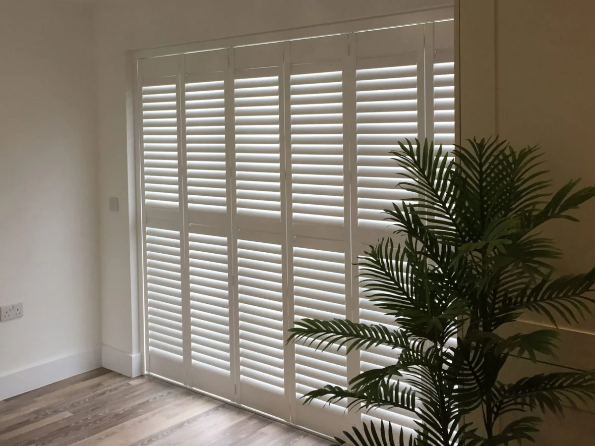 Tracked shutters gliding across wide patio doors — plantation shutters fitted in Tewkesbury