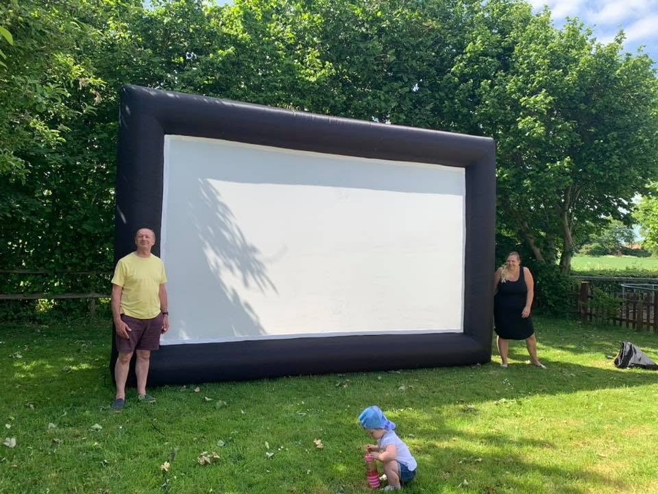 Outdoor cinema screen set up on a grassy lawn