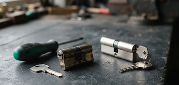 Nieuwe cilinder met twee sleutels naast de uitgenomen oude cilinder