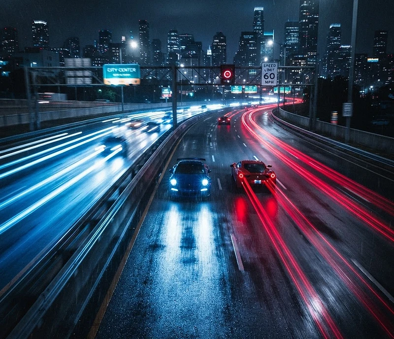 Cars moving fast at night in blue and red light