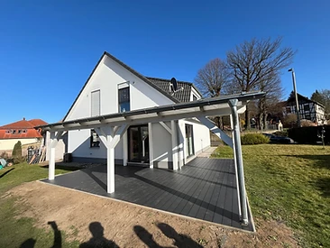 Terrassenüberdachung aus Holz mit Eindeckung über dunklem Holzdeck