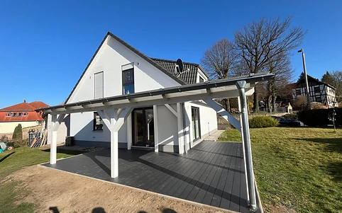Terrassenüberdachung aus Holz mit Eindeckung über dunklem Holzdeck